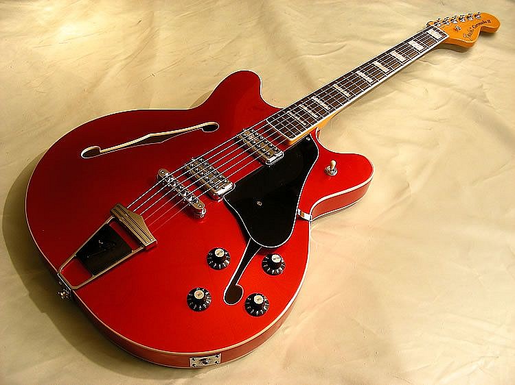 FENDER Guitars, Coronado, 2013
Maple body and neck, 25 1/2 in. (64.8 cm)
The very un-Fender like instrument was designed by Roger Rossmeisl (who had previously also designed instruments for Rickenbacker, but who went on to create numerous models for Fender) in an attempt to capitalise on the increasing popularity of semi-acoustic guitars following the high-profile use of hollow-bodied instruments, such as the Epiphone Casino by bands like The Beatles. During Rossmeisl's time designing for Fender he also designed the Fender Montego, a jazz box style guitar which shares the Coronado's fixed F tailpiece; and the 1967 Fender Wildwood which shares the Stratocaster headstock.
Three versions of the Coronado guitar were produced from 1966 through 1972. The Fender Coronado I, discontinued in 1970, was the original single pickup design. The Coronado II had an added bridge pickup (with relative tone and volume controls). The Coronado XII, released in 1967, was a twelve-string version of the guitar. Coronado basses were also manufactured. The Coronado was a true hollow-bodied electric guitar; like the Gibson ES-330 and Epiphone Casino, it did not have a central solid wood block in the body. This is in contrast to guitars such as the Gibson ES-335, which, although appearing similar, were constructed with a solid central block running lengthways through the archtop body.
The top, sides and back of the body on the Wildwood body were constructed from laminated beechwood, and maple was used for the non Wildwood versions, the top being slightly arched, and featuring two generous, routed and bound 'f' holes. The body of the instrument was finished in a high-gloss nitrocellulose lacquer, a finish which is no longer frequently used in the manufacture of modern guitars. A number of Coronado II and Coronado XII guitars were offered in a special 'Wildwood' finish. This involved specially prepared, heavily-grained beechwood; a chemical dye was injected into the growing trees, years prior to harvesting, which stained the grain pattern of the wood. Only one Blonde Coronado is known to exist, it is in a private collection in California. (If this Blonde Coronado has Black Binding, it is Olympic White that has 'yellowed' over the years)
G-FENDER-001